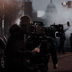 a man holding a camera in front of a crowd on a city street at night