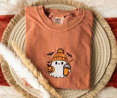 Embroidered Howdy Ghost Comfort Colors T-shirt This soft and high quality comfort colors pumpkin embroidered t-shirt is going to be your new favorite fall t-shirt! Features Brand: Comfort Colors Color: Yam (Also available in Black and Pepper) 6.1 oz., 100% ringspun cotton Preshrunk, soft-washed, garment-dyed fabric 1" ribbed collar with double-needle topstitched neckline Double-needle stitched sleeves and bottom hem Twill taped shoulder-to-shoulder Set-in sleeves 🌺 Design size 4'', placed on th Halloween Embroidered Crew Neck T-shirt, Fall Embroidered Graphics Short Sleeve T-shirt, Fall Embroidered Short Sleeve T-shirt, Embroidered Short Sleeve T-shirt For Fall, Casual Embroidered Halloween T-shirt, Fall Shirts For Women, Cute Clothes, Trendy Fall, Halloween Tees