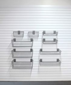 four metal baskets sitting on top of each other in front of a white garage door