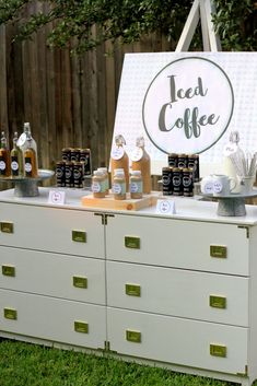 a white dresser with lots of bottles on it and a sign that says iced coffee