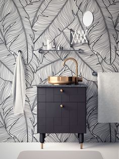 a bathroom with black and white wallpaper, gold faucet, sink and mirror