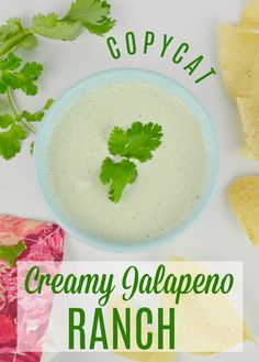 a bowl of creamy jalapeno ranch next to tortilla chips and cilantro