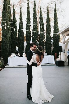 a bride and groom standing in front of an outdoor venue