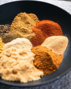 various spices in a black bowl on a table