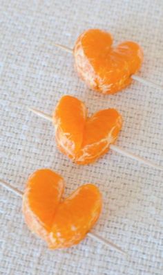 three peeled oranges sitting on top of a table