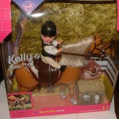 a toy horse with rider and saddle in a plastic box on a table top next to a pink brick wall