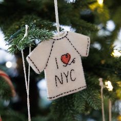 an ornament hanging from a christmas tree in the shape of a t - shirt