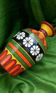 a colorful vase sitting on top of a green cloth