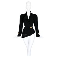 Stunning Thierry Mugler jacket, featured on the 1993 Runway show. Documented archival Collectors piece. This jacket is drama & elegance! Timeless elegance and avant-garde sophistication. The jacket's silhouette is a sculptural marvel, meticulously tailored to highlight the natural contours of the body. Crafted from luxurious black wool, it features a sharply asymmetrical front ornament that creates a dramatic, angular line down the torso. The single gold tone metal detail at the waist serves as a striking focal point, adding a touch of opulence. Fitted waist, powerful feminne silhouette. This juxtaposition of strong and delicate elements is a hallmark of Mugler’s design philosophy. The sleeves are accented with metal hardware, mirroring the closure and adding to the cohesive, polished look Mugler Jacket, 1993 Runway, Orange Jacket, Design Philosophy, Natural Contour, Metal Detail, Thierry Mugler, Runway Show, Short Coat