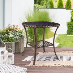 an outdoor patio with potted plants and rugs on the floor next to it