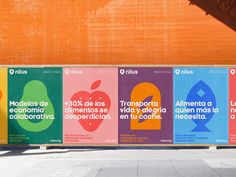 a row of colorful posters sitting on the side of a building