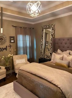 a large bed sitting in a bedroom under a chandelier