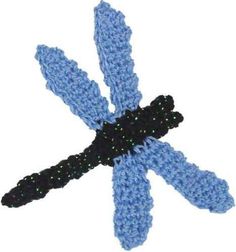 a crocheted blue dragonfly with black spots on it's wings and tail