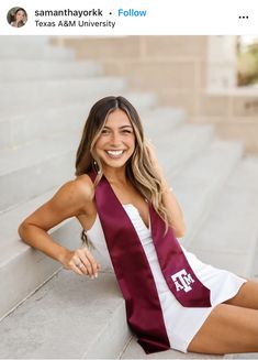 a woman sitting on the steps wearing a maroon and white graduation stole with texas a & m university