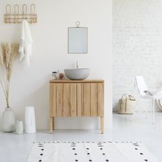 a bathroom with white walls and wooden furniture