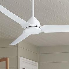 a white ceiling fan mounted on the side of a house