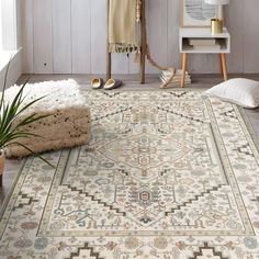 a large rug in the middle of a room with white walls and wooden floors, along with a potted plant