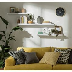 a living room filled with lots of furniture next to a wall mounted clock on the wall