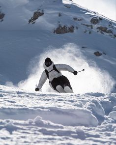 a man riding skis down the side of a snow covered slope