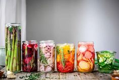 several jars filled with different types of vegetables