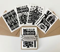 five cards with black and white designs on them, sitting next to some envelopes