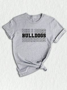 Show your Bulldogs team spirit with this stylish and comfortable Team Mascot Shirt!  Designed specifically for proud Bulldog supporters, this shirt is perfect for alumni, parents, and fans of the Bulldogs! Featuring a bold Bulldog Mascot design, this shirt is sure to make a statement wherever you go. Made with high-quality materials, this Bulldog Mascot Tee is exceptionally soft and comfortable to wear. Whether you're cheering on the Bulldogs from the sidelines or enjoying a casual day out, this Bulldog School Shirts, Team Spirit Shirts, Halloween Letras, Mascot Shirt, Bulldog Mascot, Bulldog Mom, Team Mascots, Spirit Shirts, Team Shirt