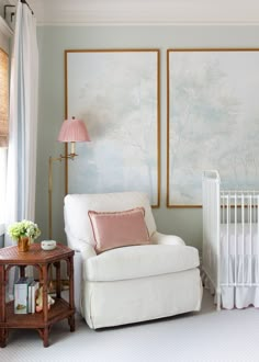 a baby's room with a crib, chair and painting on the wall