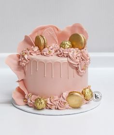 a pink cake with gold decorations on top