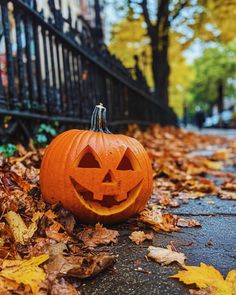 a pumpkin carved to look like a jack - o'- lantern sitting on the ground