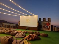 an outdoor movie screen is set up on the roof of a building at night time