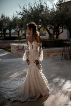 a woman in a wedding dress is standing outside