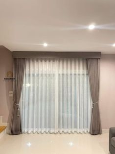 an empty living room with white walls and curtains