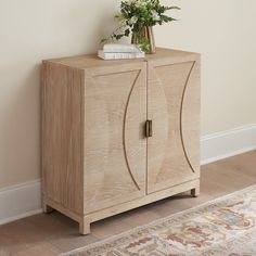 a wooden cabinet sitting on top of a rug next to a wall with a plant in it