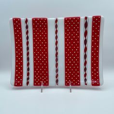 a red and white striped glass plate with polka dots on the edge, set against a white background