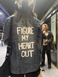 a person wearing a jean jacket that says figure my heart out on the back,