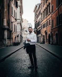 a man is standing in the middle of an alleyway with buildings on both sides