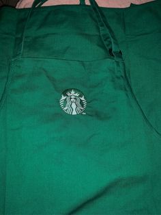 the starbucks logo is on the side of a green bag that has been folded over