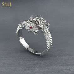 Enter the realm of ancient legends and mythical creatures with our Sterling Silver Chinese Dragon Head Adjustable Ring. This captivating piece of jewelry is crafted with exquisite detail and inspired by the majestic dragons of Chinese mythology. Crafted from high-quality 925 sterling silver, this ring features a stunning dragon head design that wraps around your finger. The adjustable band ensures a comfortable fit for both men and women, making it a versatile accessory for any occasion. Whether Sterling Silver Dragon Design Ring, Silver Fantasy Jewelry With Dragon Design, Fantasy Silver Jewelry With Dragon Design, Dragon Design Anniversary Ring Jewelry, Unique Sterling Silver Ring With Dragon Design, Anniversary Dragon Design Ring, Sterling Silver Fantasy Jewelry With Dragon Design, Unique Silver Jewelry With Dragon Design, Silver Snake Ring With Dragon Design In Sterling Silver