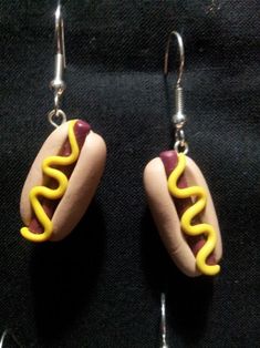 a pair of hotdogs with mustard and ketchup earrings