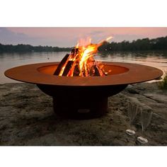 a fire pit sitting on top of a sandy beach