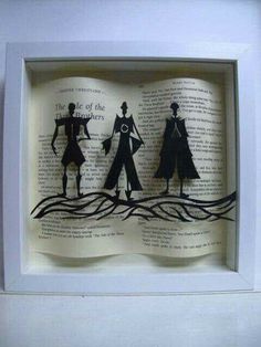 an open book with some paper cut out of it's sides and people on the pages