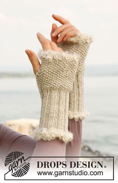 a woman wearing a pair of beige knitted mittens