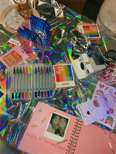 a table topped with lots of different types of art supplies and books on top of it