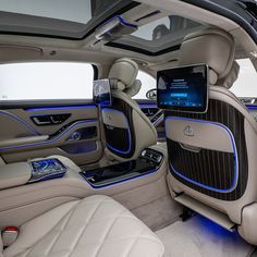 the interior of a luxury car with blue lights and electronic gadgets on it's dashboard