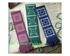 three crocheted bookmarks are sitting on top of an open book