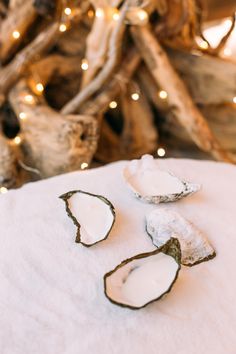 three pieces of food sitting on top of a white cloth covered in icing next to a christmas tree