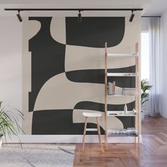 an abstract black and white wall mural in a living room with wooden flooring, bookshelf and shelves