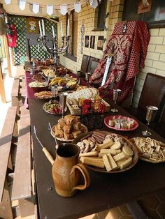 a table full of food and drinks on top of a wooden table with bunting