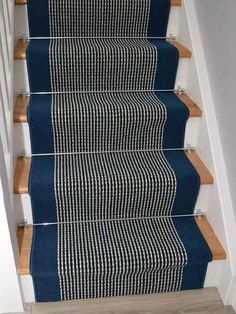 blue carpeted stairs with wooden handrails