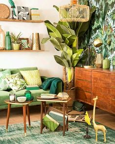 a living room with green furniture and plants on the wall, in an instagramture